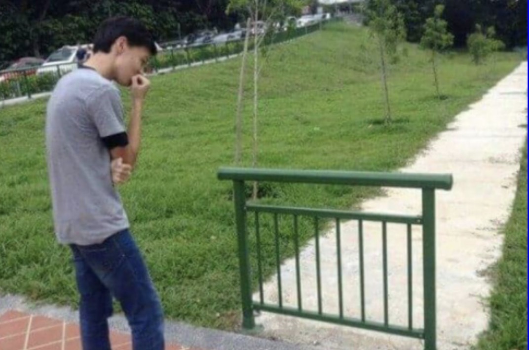 A short railing across part of a pathway, with open pavement beside it
